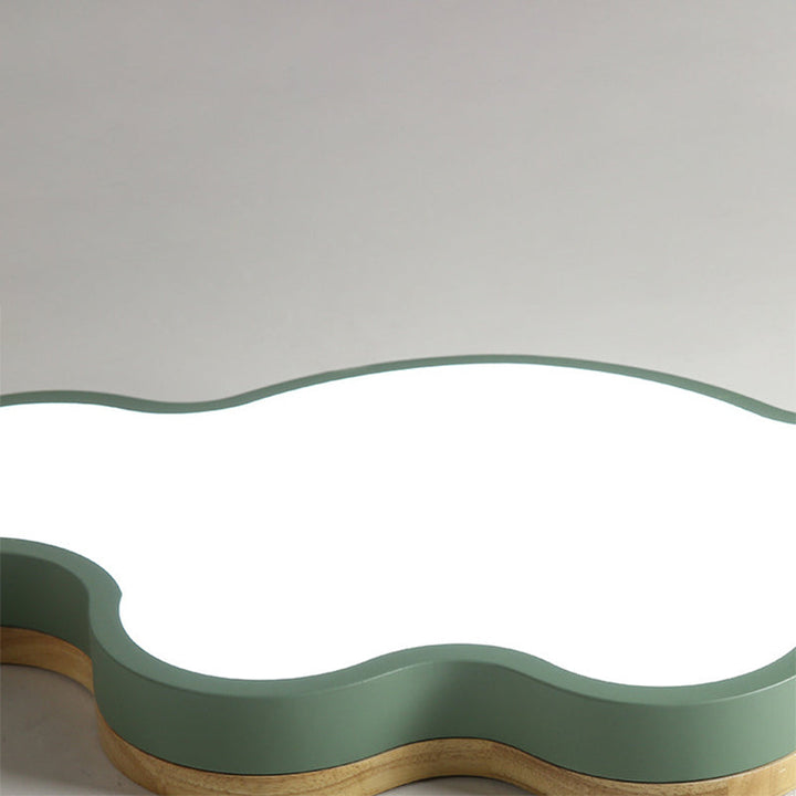 Close-up of green metal cloud ceiling lamp with wooden trim and soft acrylic diffuser.