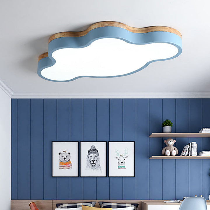 Cloud-shaped Nordic ceiling light with blue frame and wood trim in a child’s bedroom, creating a playful Scandinavian atmosphere.