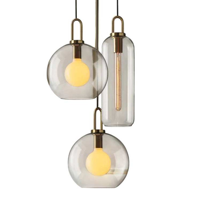 Cluster of clear glass pendant lights with metal tops featuring globe and cylinder shapes in Nordic minimalist design
