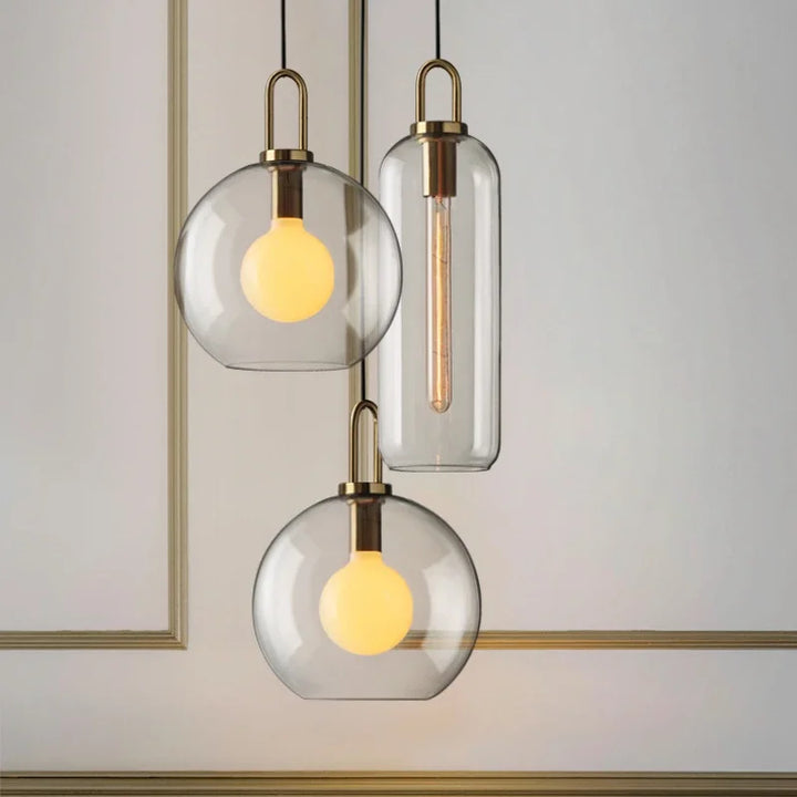 Cluster of clear and frosted glass pendant lights with metal accents in minimalist interior