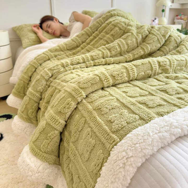 Soft green faux lambswool blanket on bed, thick coral fleece design for cosy Scandinavian-inspired bedroom décor