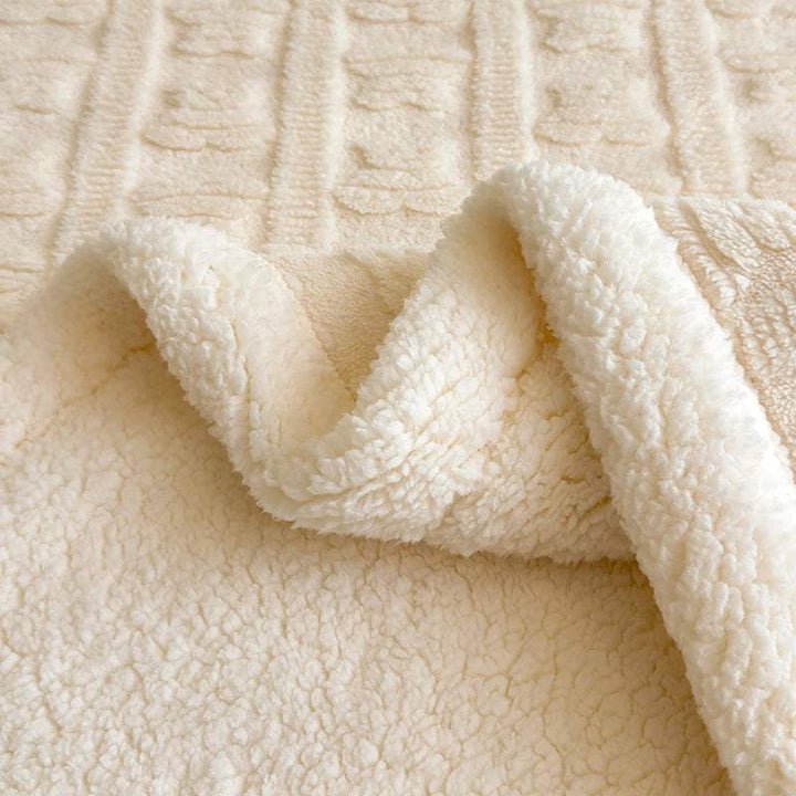 Close-up of cream sherpa fleece blanket, ultra-soft faux lambswool fabric with elegant Nordic weave