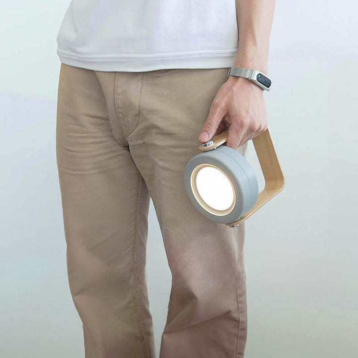 Portable LYKT rechargeable LED lamp carried by handle, great for moving between rooms or outdoor evenings.