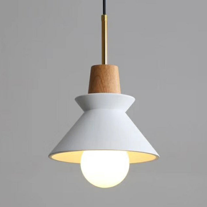White cement pendant light with wood top, hanging from brass rod in Nordic-inspired home.