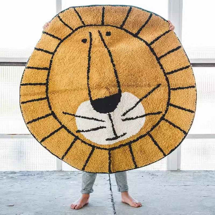 Large lion face rug held by child, soft faux cashmere round mat for playful nursery or bedroom.