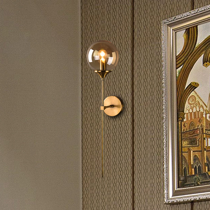 Amber glass globe wall light with brass base mounted on patterned wallpaper, adding vintage Scandinavian charm.
