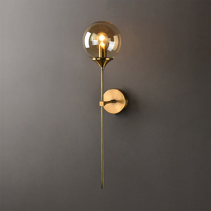 Amber-toned brass and glass wall sconce with soft lighting, perfect for contemporary interiors.