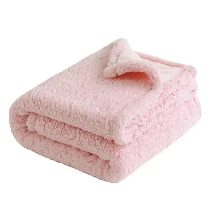 Folded pink waterproof sherpa blanket, ultra-soft flannel bedding for minimalist Scandinavian interiors.