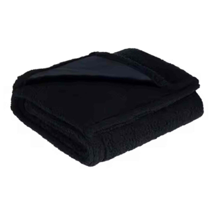 Folded black waterproof flannel sherpa blanket, durable and warm bedding for minimalist interiors.