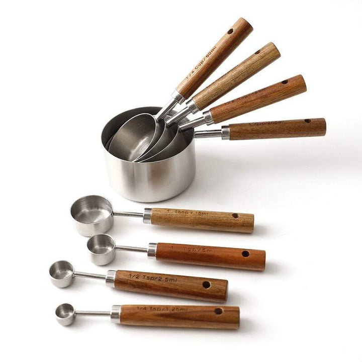 Stainless steel measuring cups and spoons with wooden handles in minimalist Nordic design