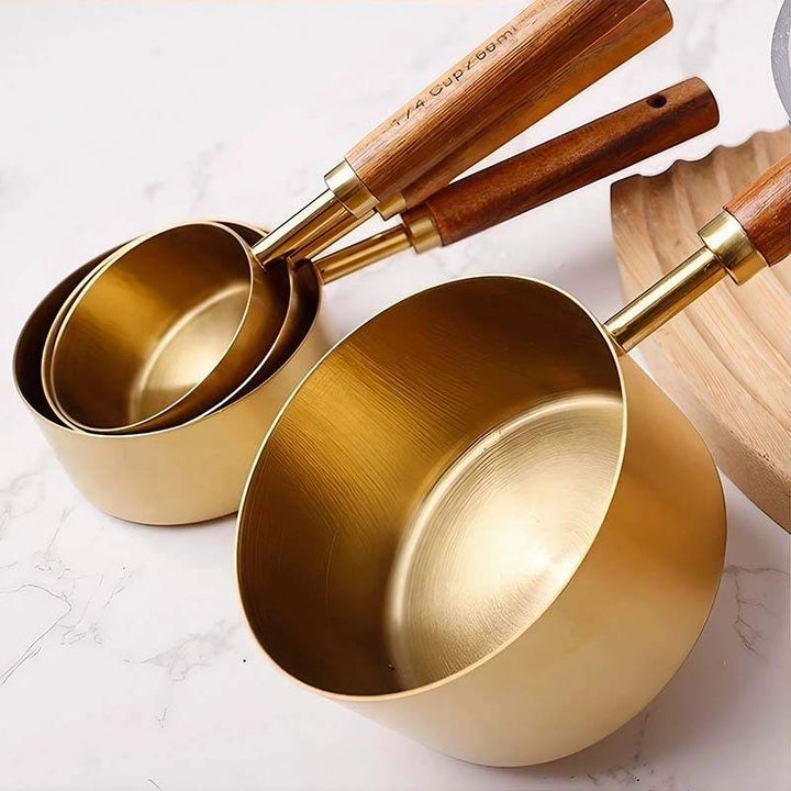 Gold stainless steel measuring cups with wood handles showing elegant Scandinavian finish