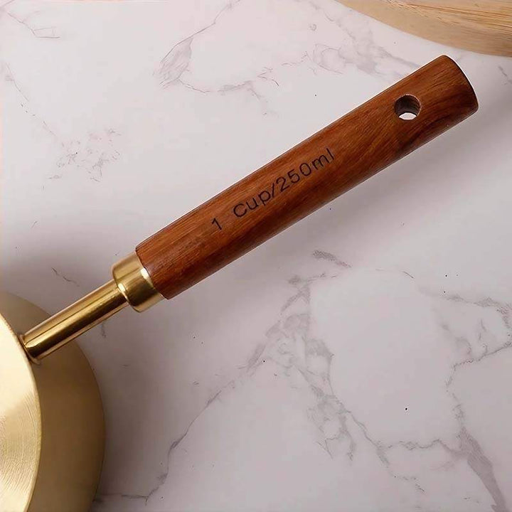 Close up of engraved 1 cup 250ml marking on wooden handle of gold measuring cup